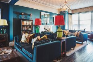 a living room with blue walls and blue furniture at No.26 By The Sea in Oban