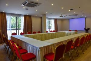 uma sala de conferências com uma mesa longa e cadeiras vermelhas em Admas Grand Hotel em Entebbe