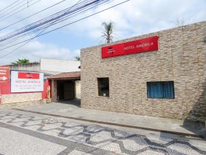 a brick building with a red sign on it at Hotel America in Jacareí