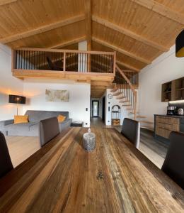ein Wohnzimmer mit einem Holztisch und einer Treppe in der Unterkunft Antonya Apartments in Schenna