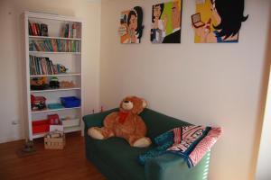 a teddy bear sitting on a green couch in a room at Chuditch Holiday Home Dwellingup - Great Central Location in Dwellingup