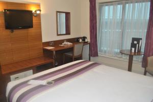 a hotel room with a bed, television and a desk at Legacy Preston International Hotel in Preston