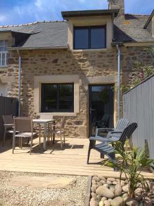 a patio with chairs and a table in front of a house at Maison Cosy entre CAP FREHEL et SAINT MALO 1km PLAGE 5min GR34 Wifi Jardin Vélos "CASA OHANA" in Saint-Cast-le-Guildo