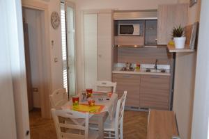 una piccola cucina con tavolo e sedie in camera di IL VECCHIO ULIVO a Cutrofiano