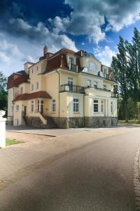 un grand bâtiment blanc sur le côté d'une route dans l'établissement Hotel Dirks am Schloss, à Bad Pyrmont