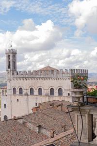 un bâtiment avec une tour d'horloge au-dessus d'un toit dans l'établissement Relais Ducale, à Gubbio