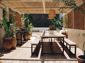 a patio with a table and benches and plants at Shila Athens in Athens