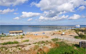 a beach with a pier in the water at Awesome Apartment In Wusterhusen in Wusterhusen