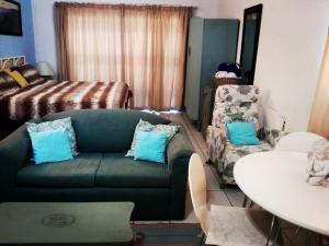 a living room with a green couch and a table at 36 Df Strauss Street in Kleinmond +29 photos