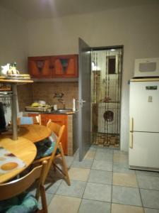 a kitchen with a table and a refrigerator at Rózsa vendégház in Abádszalók