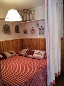 2 łóżka w sypialni z czerwonym i białym kocem w obiekcie Monolocale sulle piste w mieście Pila