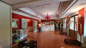 a large room with red walls and a woman in a kitchen at Saturnia Tuscany Hotel in Saturnia