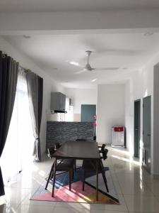 a dining room with a table and chairs in a room at Baituljannah Homestay Batu Pahat in Batu Pahat +15 photos