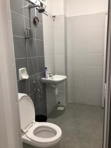 a bathroom with a toilet and a sink at Baituljannah Homestay Batu Pahat in Batu Pahat