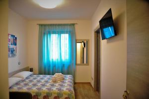 1 dormitorio con 1 cama y TV en la pared en Angelo Lifestyle, en Bagnoli Irpino