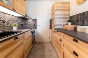 a kitchen with wooden cabinets and a sink at Apartment Elbkiez - Wohnen zwischen Elbe & Altstadt, stilvoll mit Balkon! in Dresden +20 photos