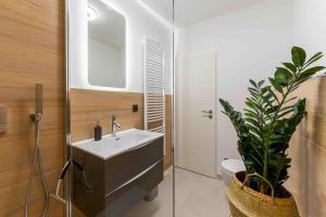a bathroom with a sink and a mirror and a plant at Apartment Elbkiez - Wohnen zwischen Elbe & Altstadt, stilvoll mit Balkon! in Dresden