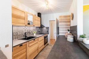 a kitchen with wooden cabinets and a sink at Apartment Elbkiez - Wohnen zwischen Elbe & Altstadt, stilvoll mit Balkon! in Dresden
