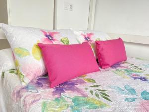 カンブリルスにあるSol Cavet con jardin Portaventuraのピンクの枕2つ(ベッドの上に座る)