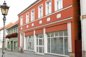 ein orangefarbenes Gebäude mit Fenstern und einem Straßenlicht in der Unterkunft Appartement Schloßstraße in Ballenstedt