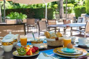 - une table avec des assiettes de nourriture et de boissons dans l'établissement Le Mas D'aigret, aux Baux-de-Provence