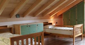 a attic room with two beds in a room at Agriturismo Malga Riondera in Ala