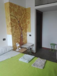 a bedroom with a bed with a tree mural on the wall at A Santy's Rooms-BAGNOCONDIVISO SHAREDBOTH ROOM2piano-no lift-3chilom a piedi xAEROPORTO-A PAGAMENTO AIR CONDIZextra bed EXTRABED FOR A FEE-3 MINUTI BUS XFIERADIROMA-10 MINUTES STOP BUS TO ROME IN50 MINUTES TRAFFICPERMITTING ARE YOU TO ROME in Fiumicino