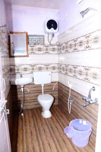 een kleine badkamer met een toilet en een wastafel bij Ushodaya Resorts in Araku