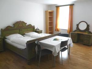 a bedroom with a bed with a table and a mirror at Hotel Schwarzes Rössl in Salzburg
