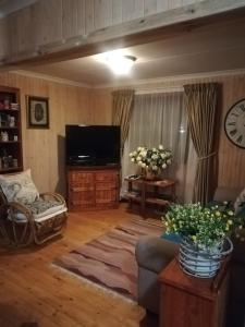 a living room with a couch and a flat screen tv at Kattekwaad Accommodation in Kaapsehoop