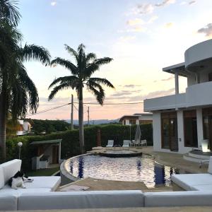 una casa con una palma e una piscina di Casa Quinta de Descanso "NUEVA ERA" Via MELGAR - CARMEN DE APICALA -GIRARDOT a Carmen de Apicalá