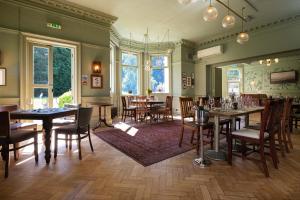 a restaurant with tables and chairs in a room at Worplesdon Place Hotel in Guildford