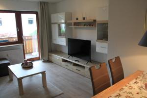 a living room with a television and a dining table at Haus Wanderlust in Willingen