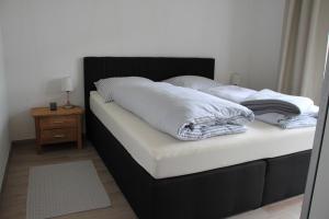 a bed with white sheets and pillows on it at Haus Wanderlust in Willingen