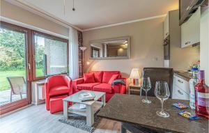 - un salon avec un canapé rouge et une table dans l'établissement Amazing Apartment In Friedrichskoog With Kitchen, à Friedrichskoog