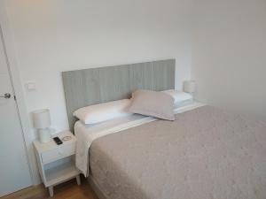 um pequeno quarto com uma cama e uma mesa de cabeceira em Acogedor apartamento en Zumaia em Zumaia