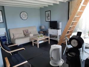 a living room with a couch and a staircase at Vakantie studio Heeg met eigen ligplaats in Heeg