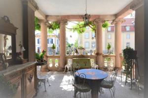 un patio con tavolo, sedie e un edificio di Castelnau a Colmar