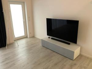 a flat screen tv sitting on a stand in a room at Gästehaus Emma in Niederkassel