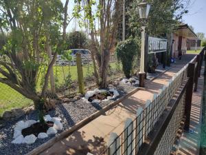 a retaining fence with rocks and trees on a street at The Booking Office, Stoke Edith Station in Hereford