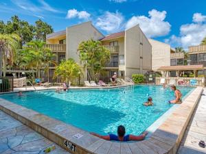 una piscina en un complejo con gente dentro en Luxury Waterfront Views - Heated Pool - 1400sf Duplex - Minutes to the Beach, en Siesta Key