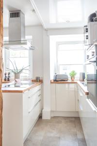 a white kitchen with white cabinets and a window at Moderne Altstadt-Ferienwohnung in Hammelburg