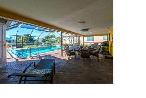 a patio with a pool and tables and chairs at Villa Flannie in Cape Coral