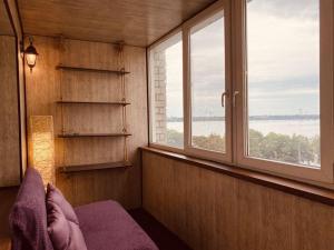 een slaapkamer met 2 ramen en een bed met een paarse deken bij LUX на Литейной 17-А in Dnipro