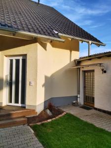a house with a door and a green lawn at Apartment zum Wohlfühlen in ruhiger Lage in Pfungstadt