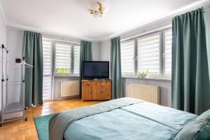 a bedroom with a bed and a flat screen tv at Staymoovers - Piękna Willa w pobliżu Krakowa in Paszkówka