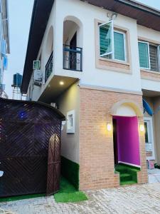 a house with a purple door and a brick at The Breeze Apartment in Ikeja