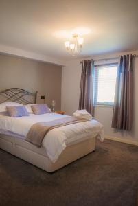 een slaapkamer met een bed en een raam bij 2 Bed Blackburn Village Apt With Wifi & Parking in Aberdeen