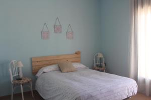 1 dormitorio con 1 cama grande y 2 sillas en EL PAJAR DE LA ABUELA, en El Toboso
