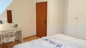 ein Schlafzimmer mit einem Bett, einem Schreibtisch und einem Tisch in der Unterkunft Daun Under in Daun